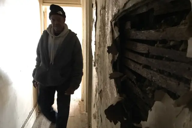 Hilton Collins, the super at 161 West 141st Street, walks through one of the apartments that has been ravaged by water and mold.